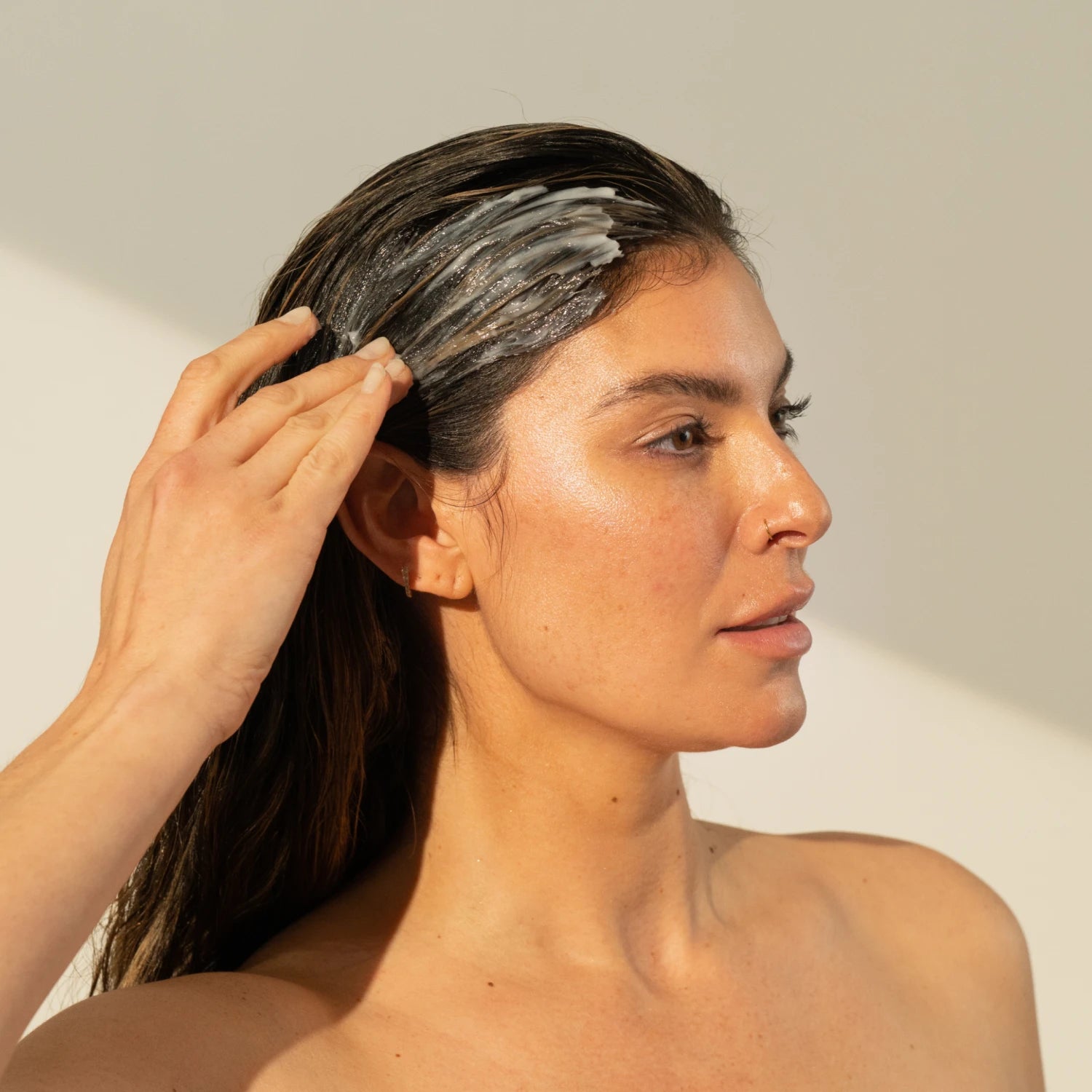 Image of woman lathering her hair with thickening conditioner