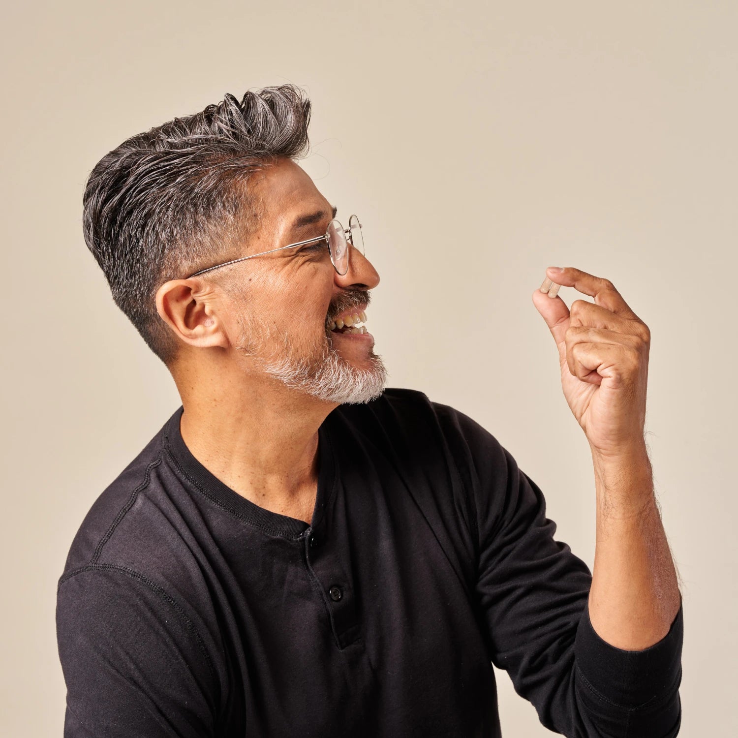 Image of a man holding a tablet of the Hair Growth Formula, about to intake the supplement.