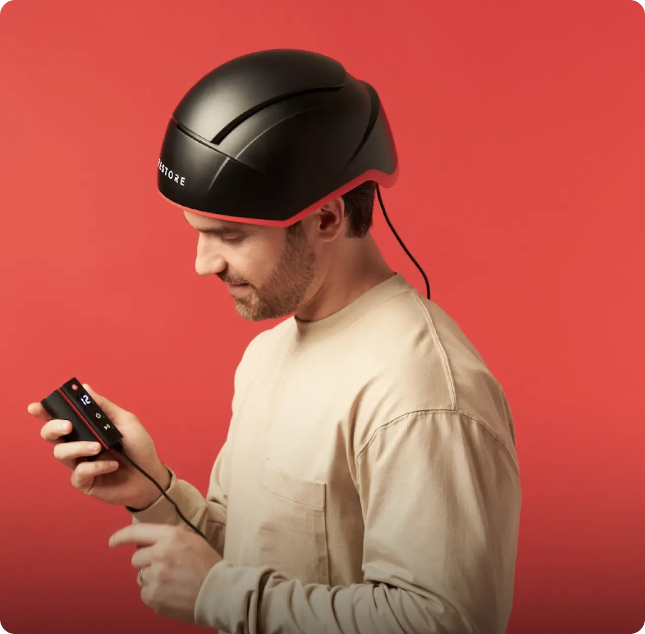 Image of a man wearing the Elite device while holding the battery pack connected to the helmet. device.