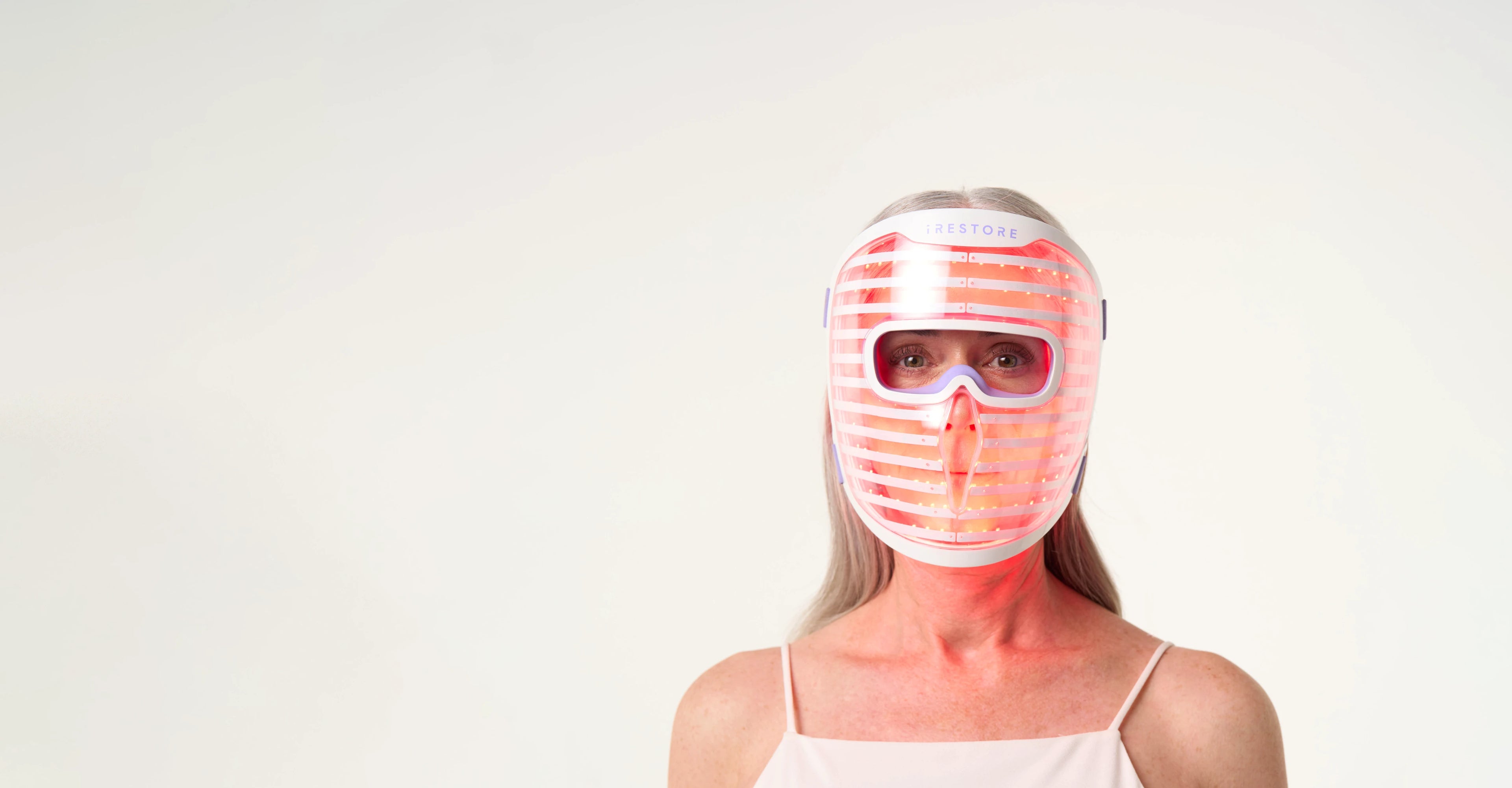 Woman wearing the iRESTORE LED face mask